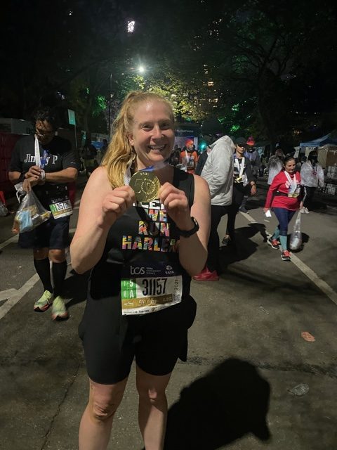 Ms.+Dolan+shows+off+the+medal+she+earned+for+completing+the+NY+Marathon.