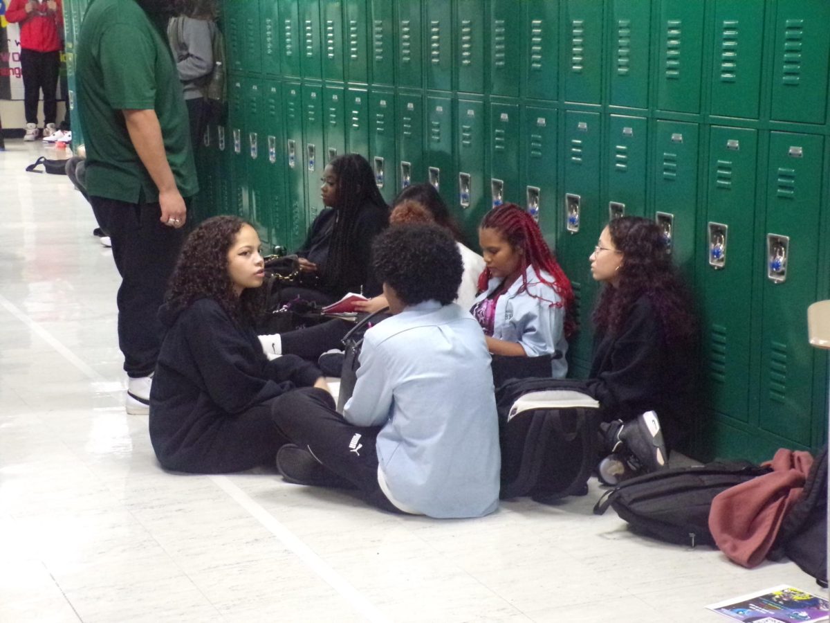 Students chat while doing their school work during lunch in the hallway.  