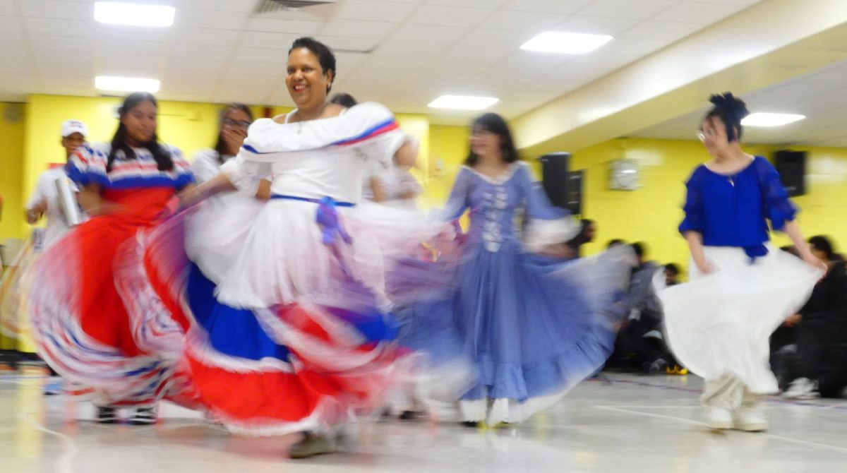 The Spanish teacher, Alfa Aquino, leads students in a dance celebrating Hispanic Culture.