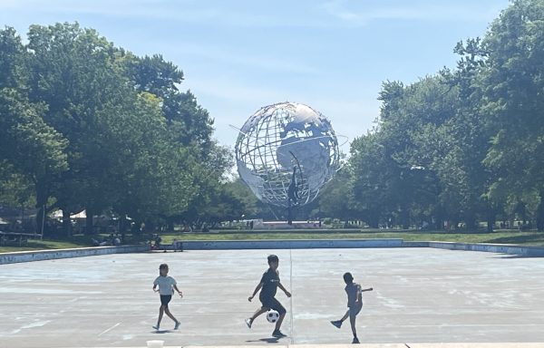 Kids playing soccer near the Unisphere at Flushing Meadows Corona Park. 