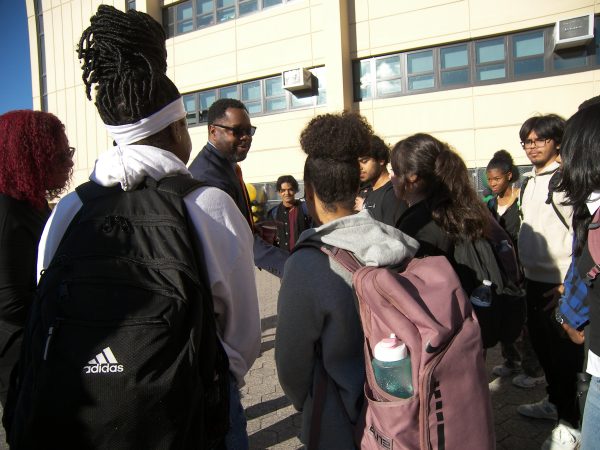 Superintendent Marcel Deans converses with students during a breakfast gathering on the terrace. 