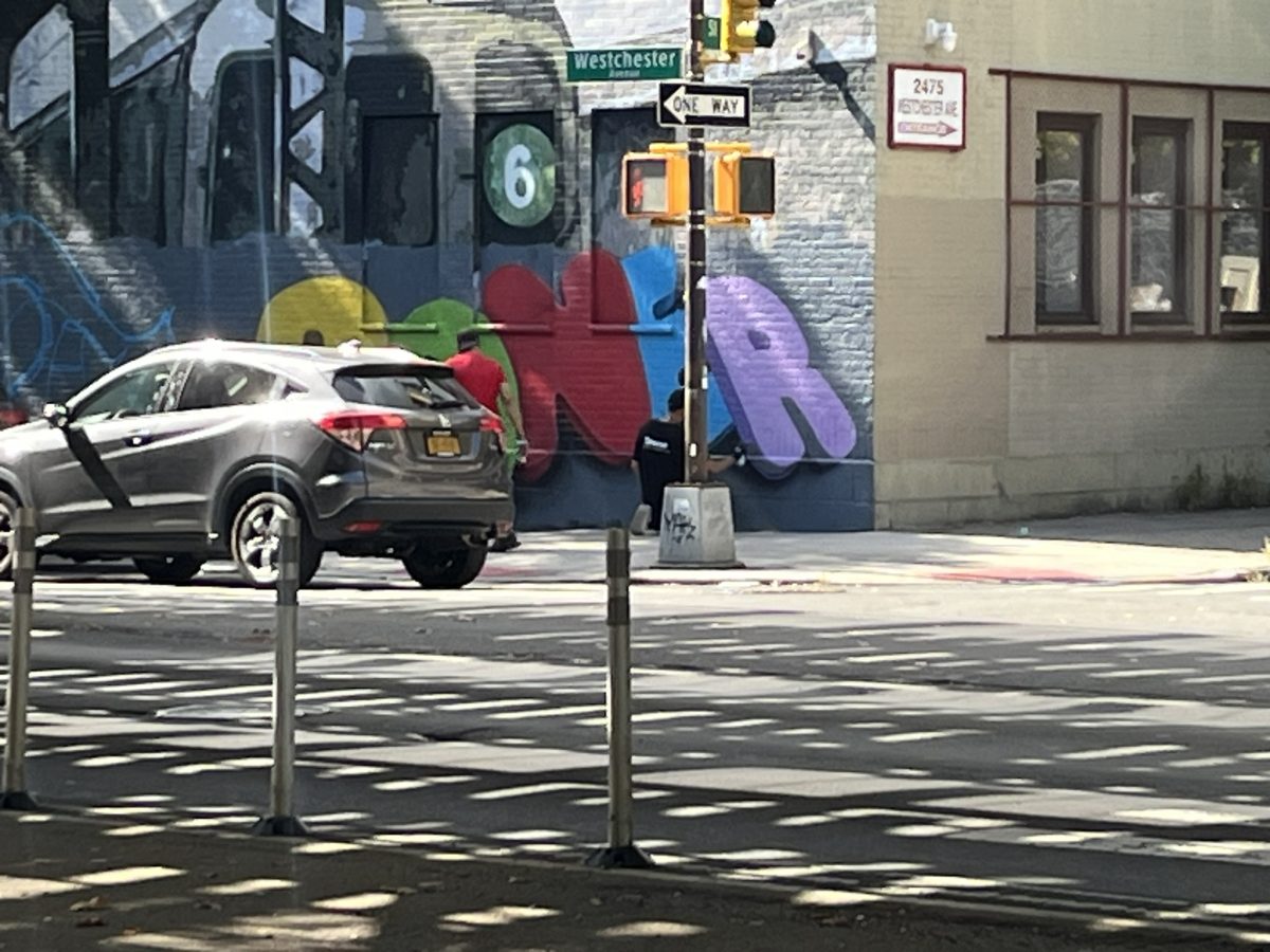 Artists by Westchester Square adding to the 6 train mural. 