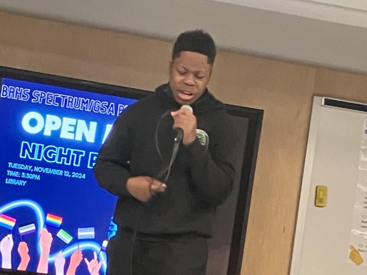 Gabriel Joseph, a junior, raps on stage at Open Mic event.