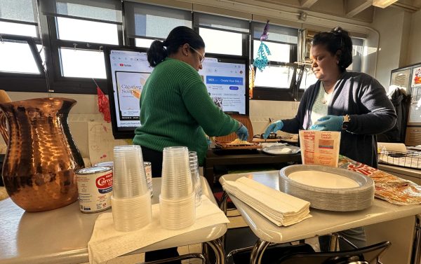 Alfa Aquino and Jemny Santana prepare traditional food for the Hispanic Club gathering.