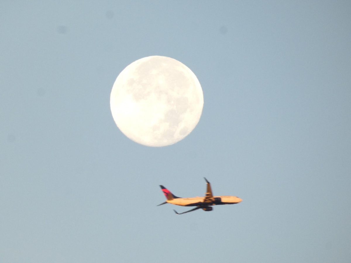 The brightest moon in the winter chases a Southwest plane in the morning.