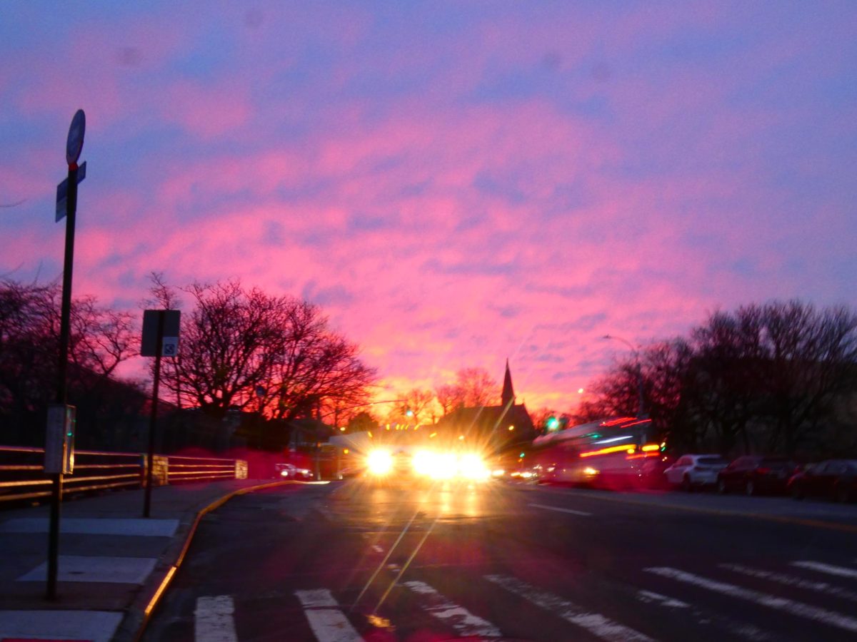 Pink clouds rise as the sun takes its first peek over East Tremont in the Bronx. 