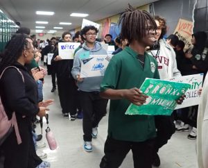Seniors carry signs highlighting their post-secondary plans during a hallway walk on Decision Day.
