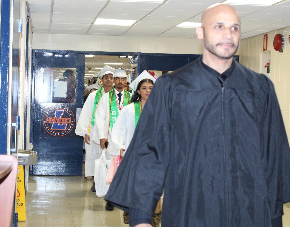 Senior guidance counselor Jovani Almonte leads the graduating class of 2025 into the auditorium for the official graduation ceremony on June 27.