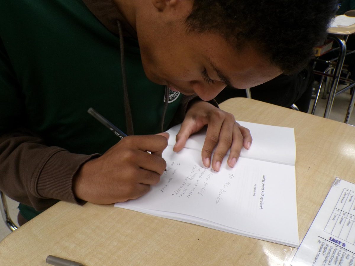 Franklin Sosa, the creator of "Notes From a Quiet Heart," autographs a copy of his book.