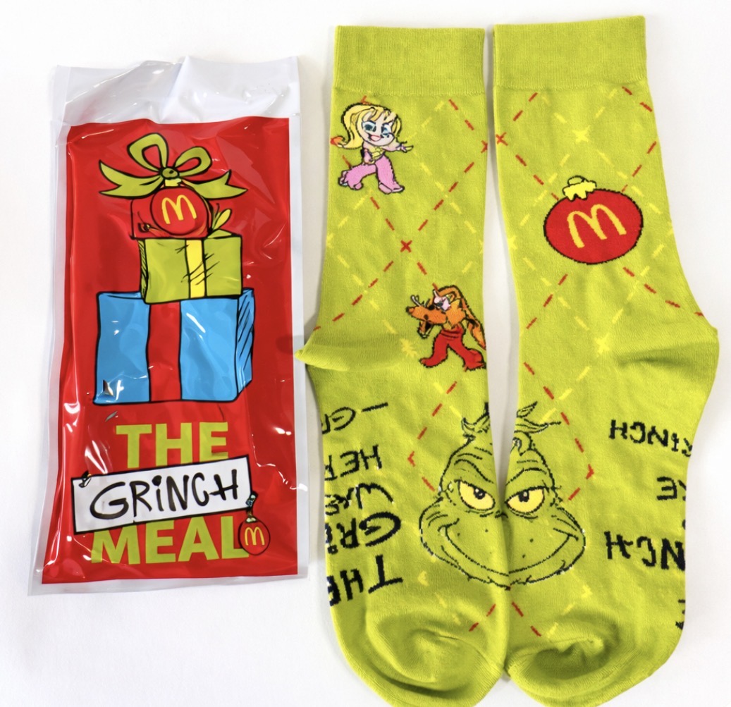 McDonald's Grinch meal comes with a pair of socks and a french fry shaker bag for the pickle seasoning.