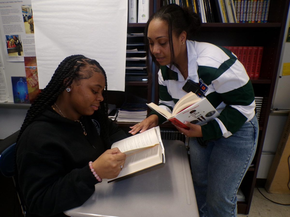 Britana Owen, a senior, and Dr. Starr Giscombe, an assistant principal, discuss a book they read. Dr. Giscombe recently fullfilled a dream to earn a doctorate degree.
